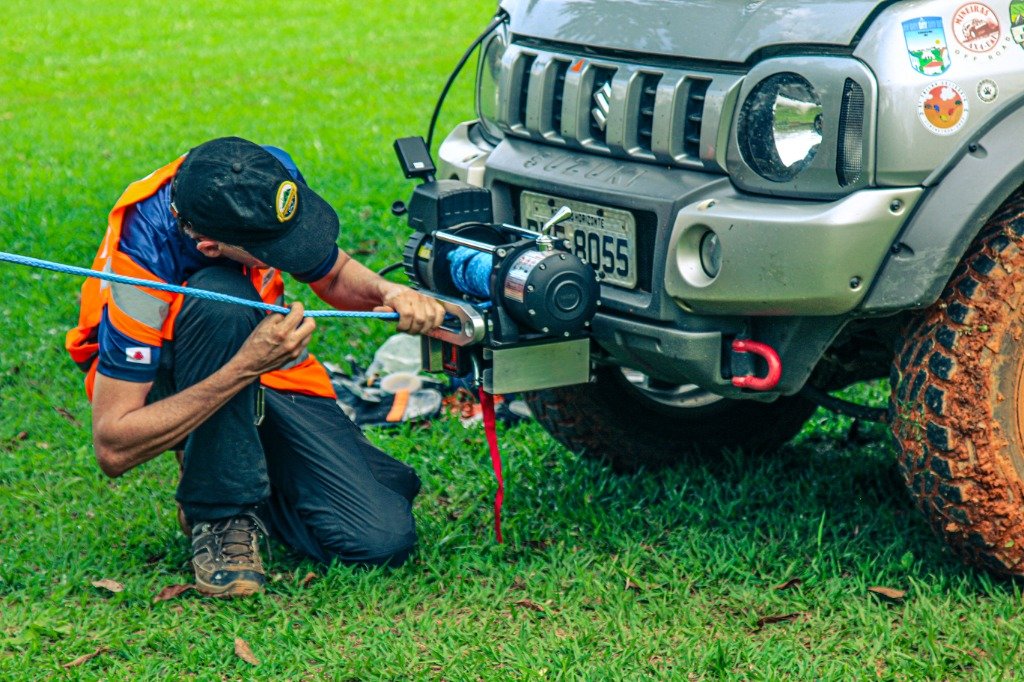 Instrutor operando guincho elétrico e cabo sintético em resgate off-road